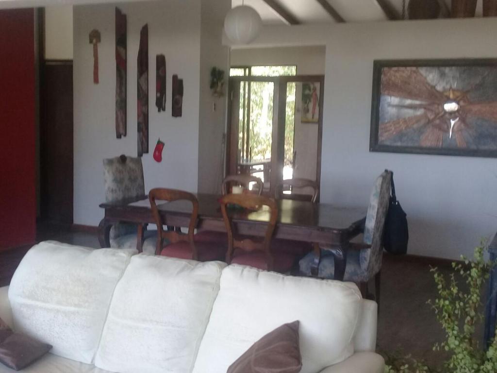 sala de estar con sofá blanco y mesa en Cómoda y amplia Casa Pueblito La Herradura Coquimbo, en Coquimbo