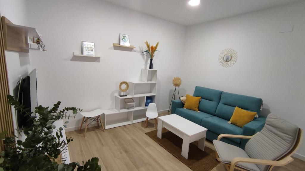 sala de estar con sofá azul y almohadas amarillas en Apartamento Flor de Córdoba en Córdoba