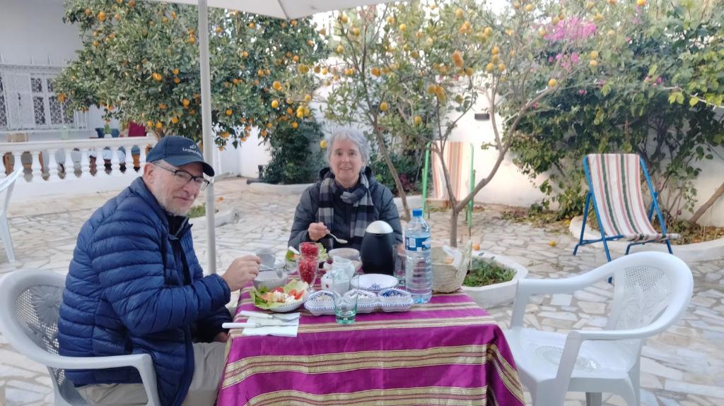 two older people sitting at a table with food on it at Henchir ejdoud in Kairouan
