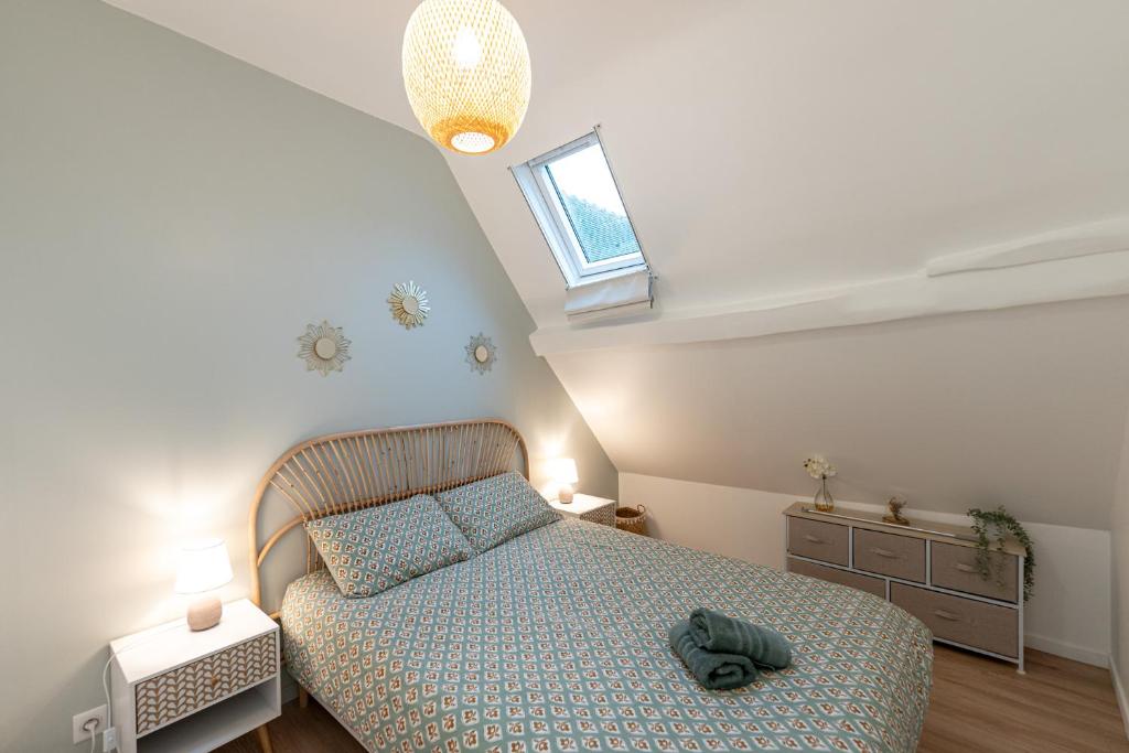 een kleine slaapkamer met een bed en een raam bij Le petit Giennois in Gien