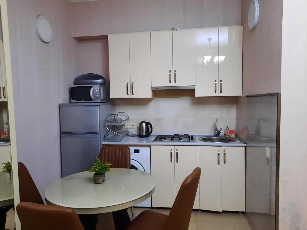 uma cozinha com armários brancos, uma mesa e um lavatório em Large apartment in Tbilisi em Tbilisi