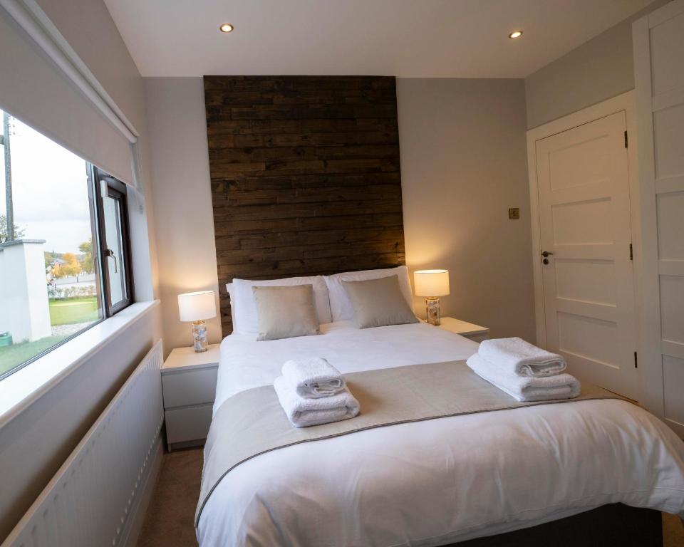 a bedroom with a large white bed with towels on it at The Hillcrest, Luxury Accommodation in Castleblayney Town in Castleblayney