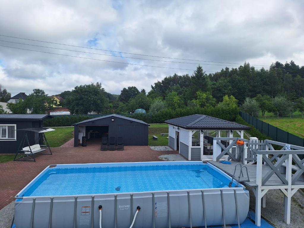 a large swimming pool in a yard with a gazebo at Chillout in Smołdzino