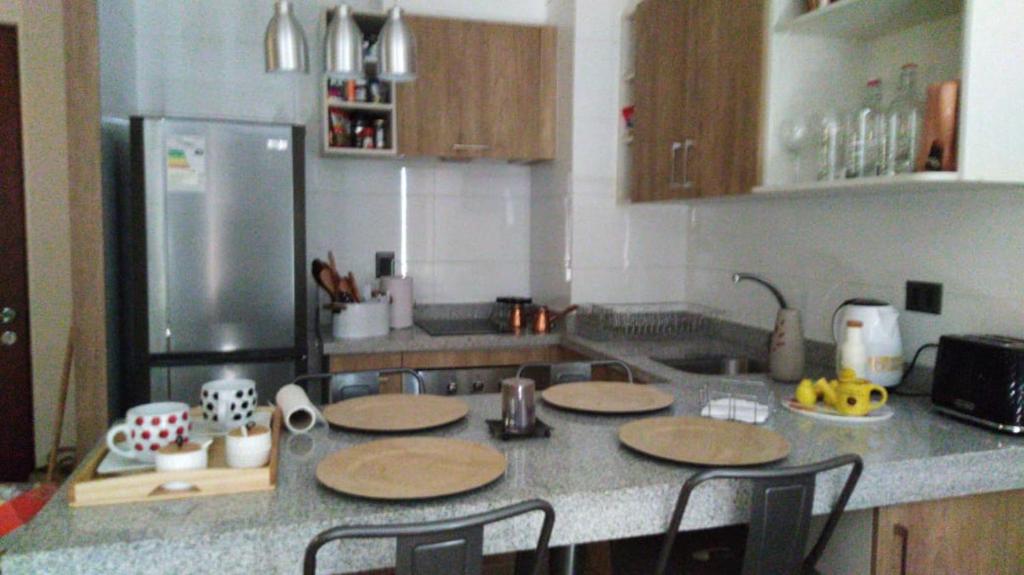 a kitchen with a counter top with wooden tables at Costanera Playa Villarrica in Villarrica