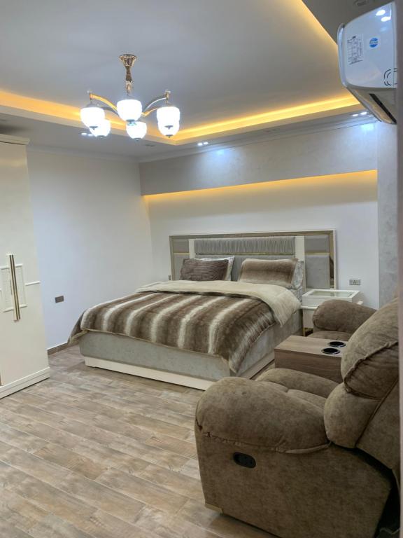 una camera con un grande letto e un divano di المهندسين a Il Cairo