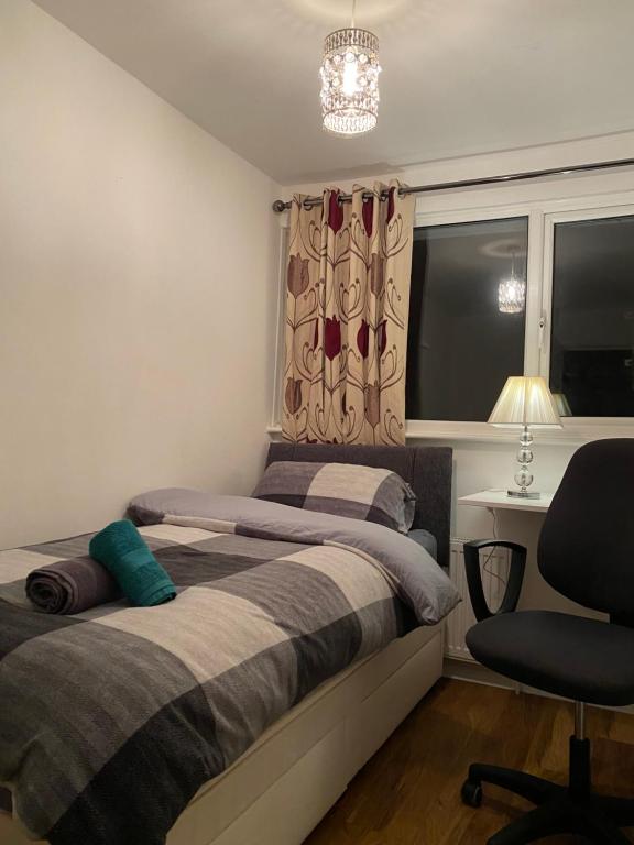 a bedroom with a bed and a chair and a window at 1 Cozy Single Bedroom With Hot Drinks in Reading
