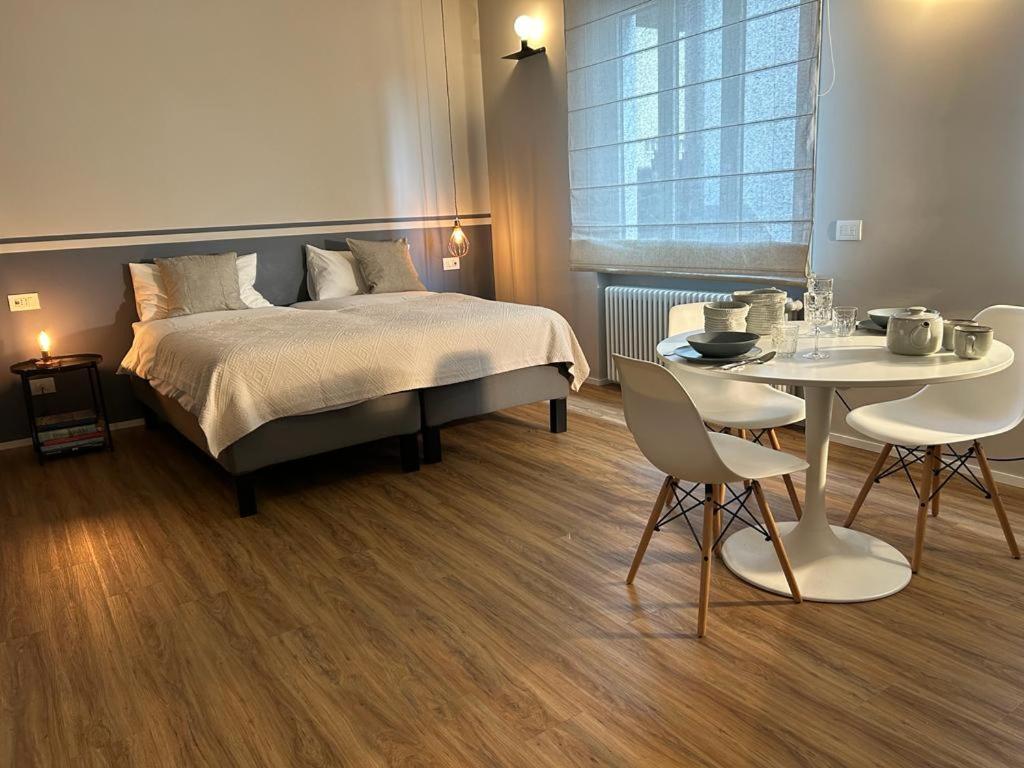 ein Schlafzimmer mit einem Bett und einem Tisch und Stühlen in der Unterkunft VillaFiera, Studio near Fiera Milano at Metro stop in Pero
