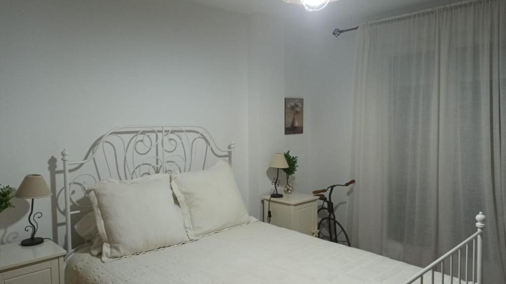 een witte slaapkamer met een bed en twee nachtkastjes bij EnFOZ PLAYAS ÚNICAS Y DIVINAS! in Foz