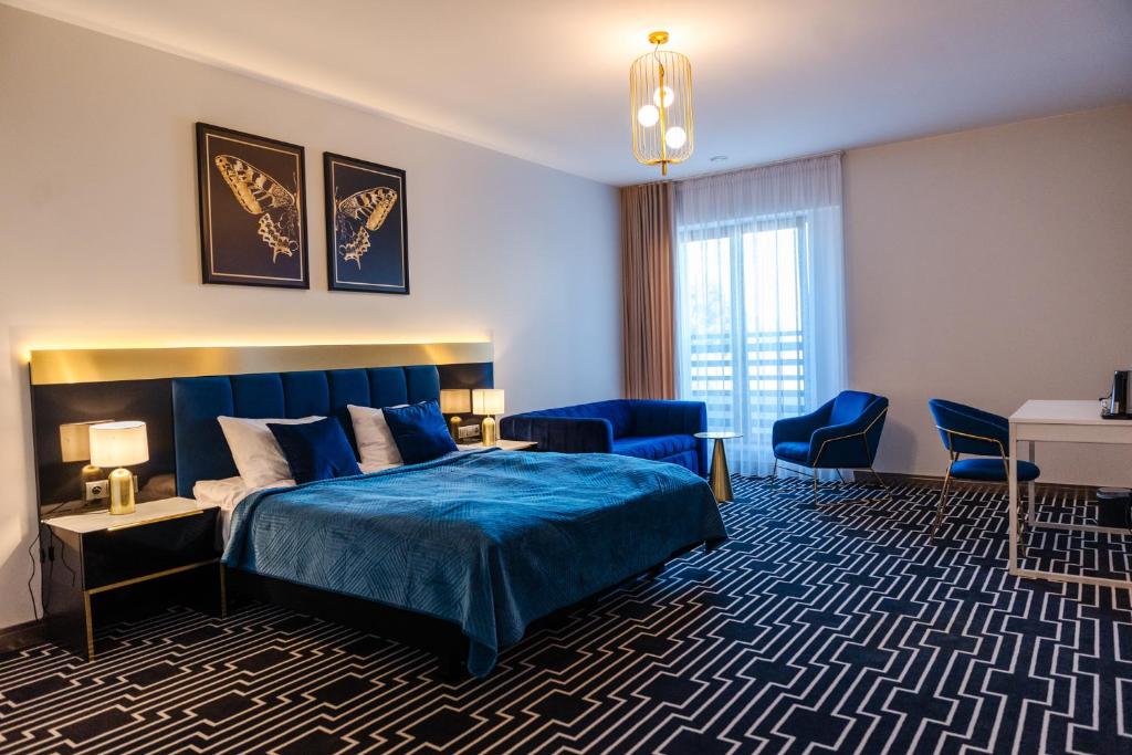 a bedroom with a blue bed and a desk and chairs at MODERNO hotel Garwolin 