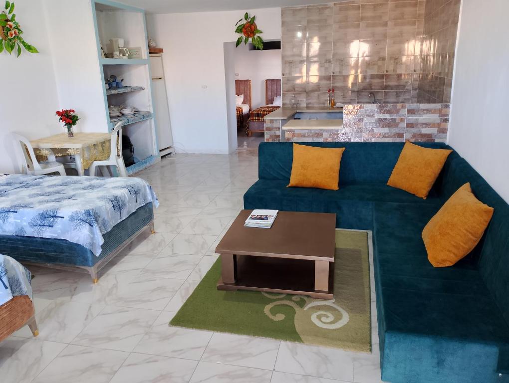 sala de estar con sofá azul y mesa en Dar ettawfik, en Tataouine