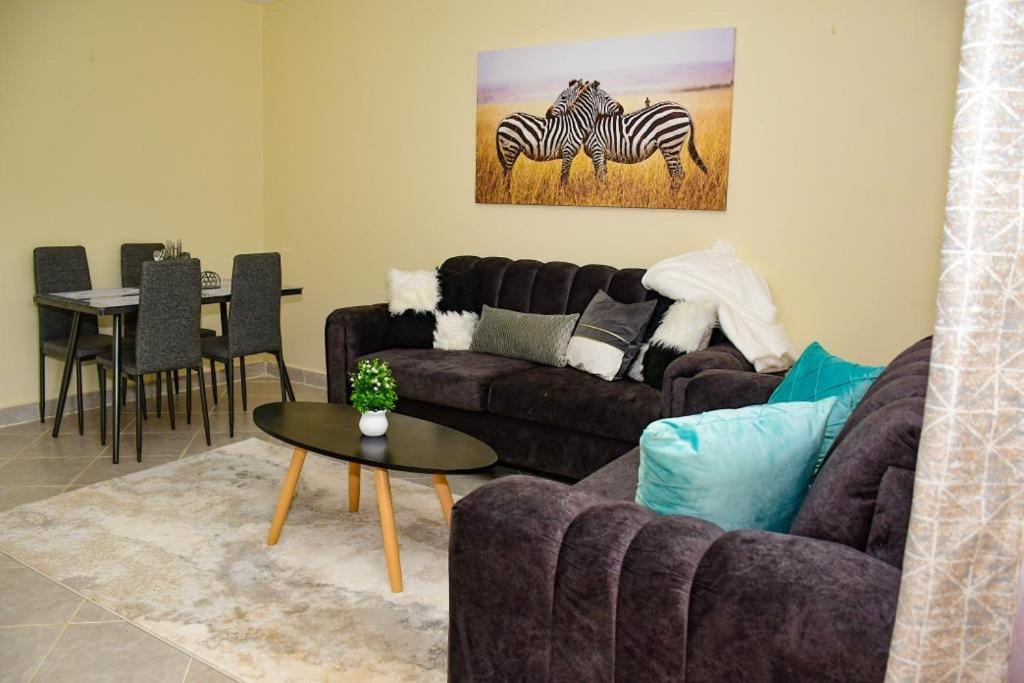 uma sala de estar com um sofá e uma mesa em Stylish 2 bedroom in Kitale Fully Furnished em Kitale