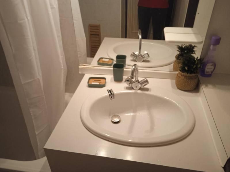 a bathroom with a white sink and a mirror at La Mongie 6 couchages pied de pistes in La Mongie