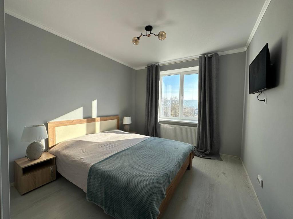 a bedroom with a bed and a large window at Sânzâiana House in Căuşeni