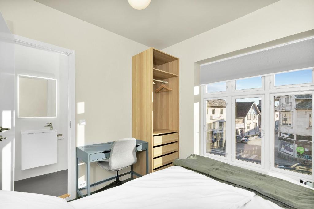 a bedroom with a bed and a desk and a window at Central Guest House - Bedroom with en suite Bathroom in Stavanger
