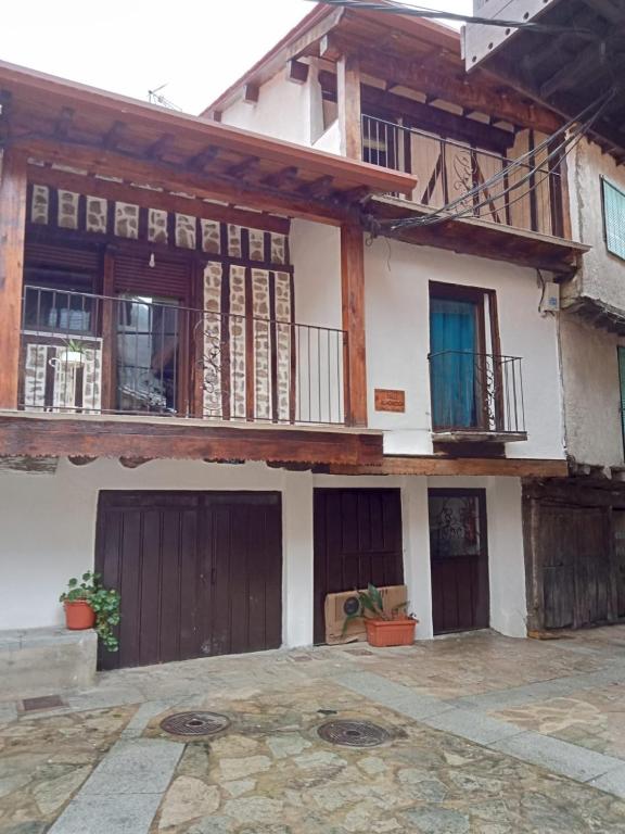 a house with two garage doors and a balcony at Casa Cefita in Madroñal