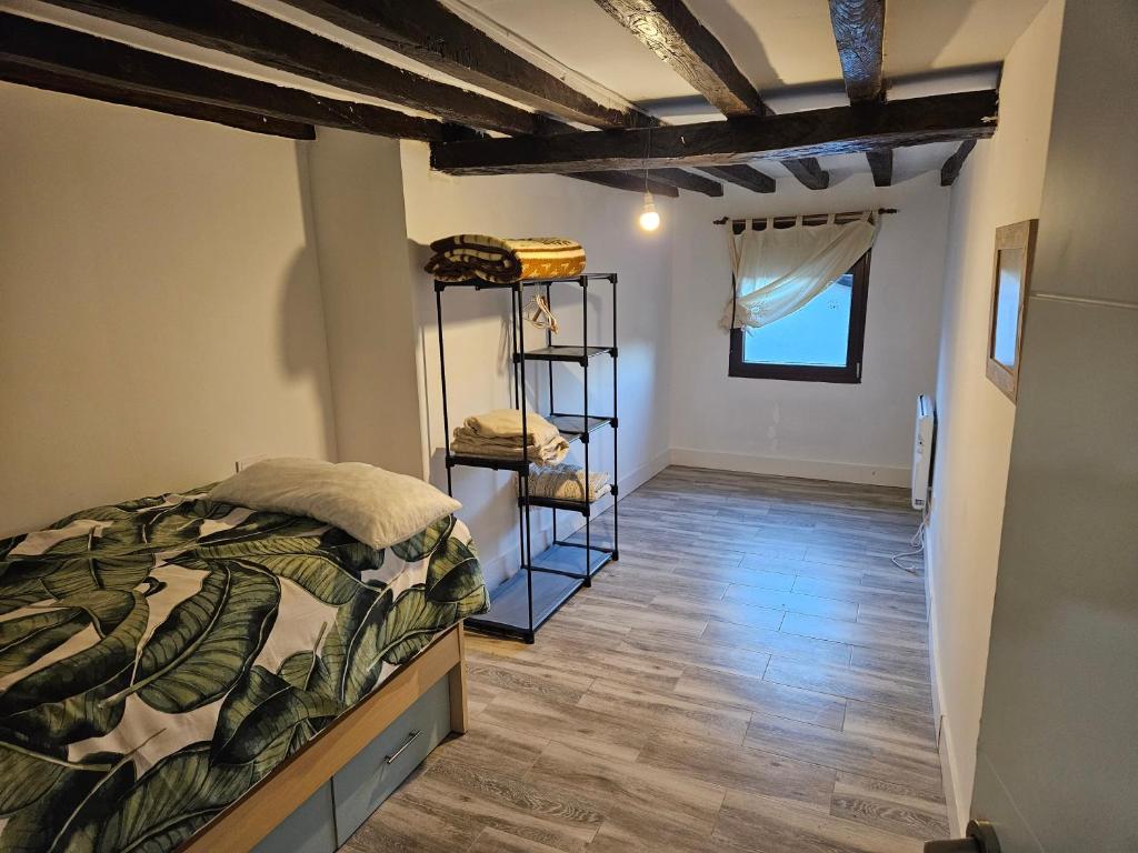 1 dormitorio con 1 cama y suelo de madera en Casa Cefita, en Madroñal