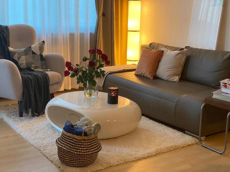 ein Wohnzimmer mit einem Sofa und einem Couchtisch in der Unterkunft Stylish flat close to Basel with a stunning view in Weil am Rhein