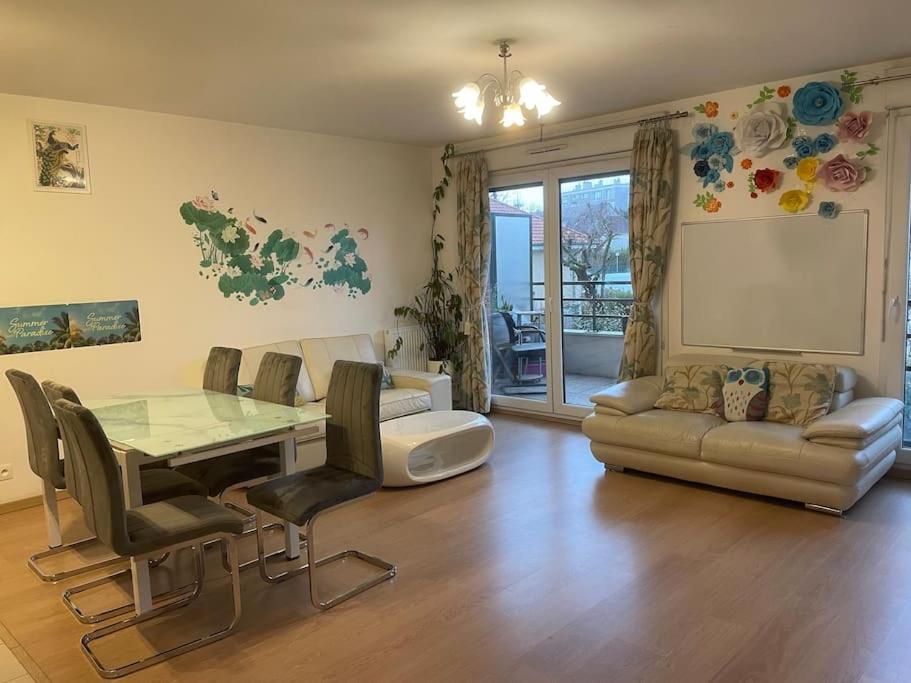 ein Wohnzimmer mit einem Tisch und einem Sofa in der Unterkunft Appartement 3 chambres avec parking, près d’Orly in Antony
