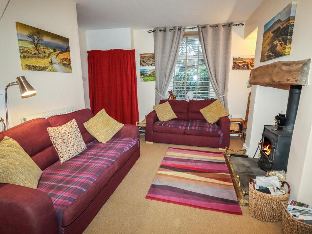 a living room with a couch and a fireplace at Winskill Cottage in Settle