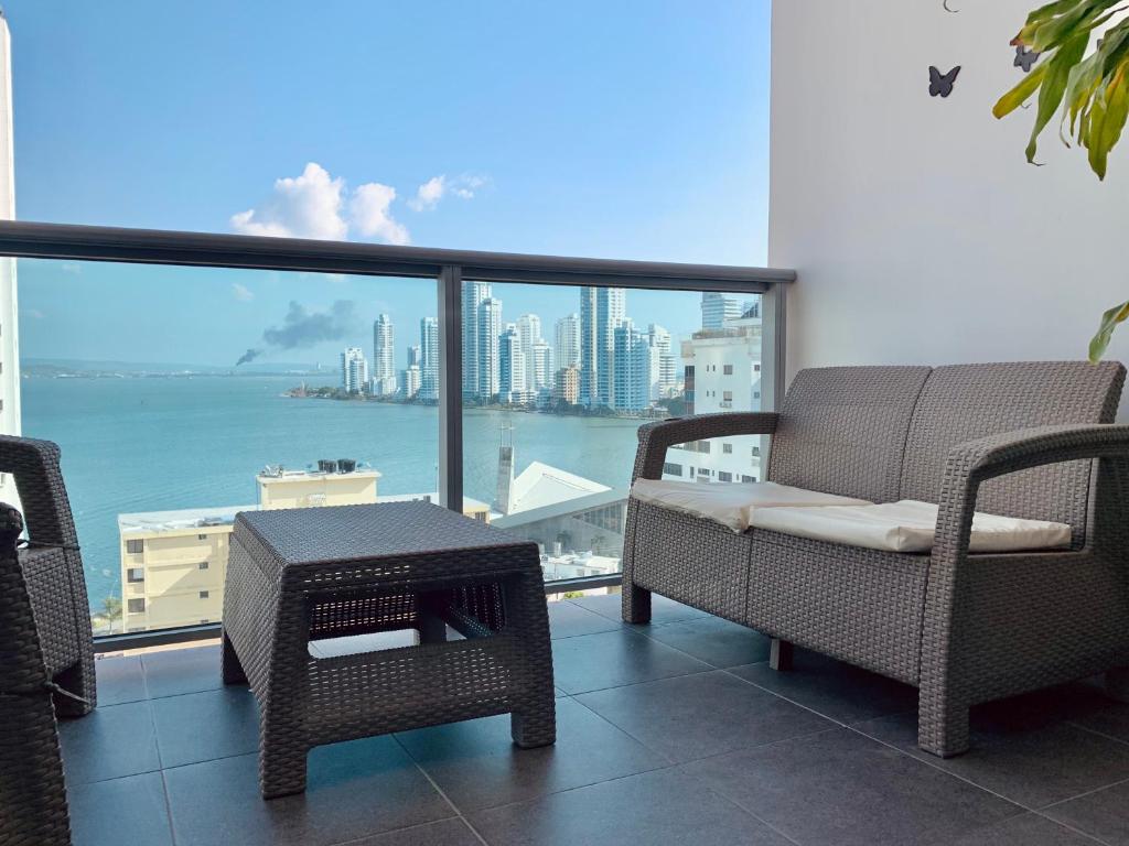 balcone con sedie, tavolo e vista sulla città di Home Beach Infinitum a Cartagena de Indias