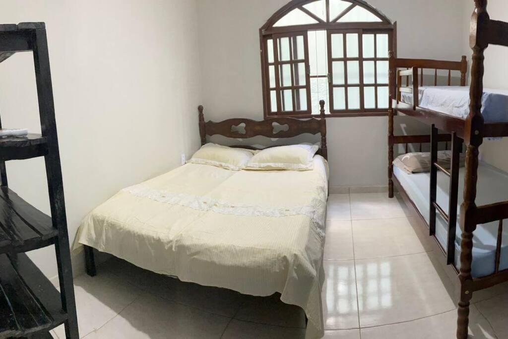 Casa Excelente Praia Grande في فانداو: غرفة نوم مع سرير وسريرين بطابقين