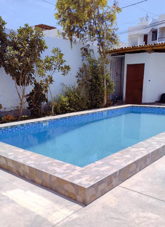 a swimming pool in front of a house at Residencia Isidora - Casa de Playa in Punta Hermosa