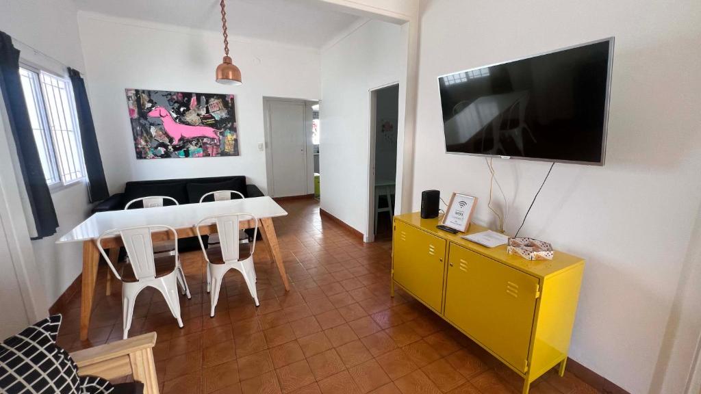 uma sala de estar com uma mesa de jantar e uma televisão em CASA EN LA FELIZ - pet friendly em Mar del Plata