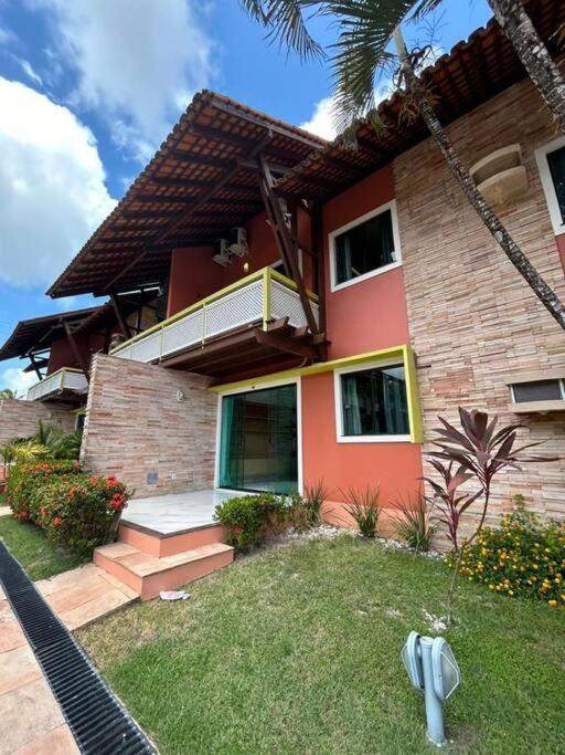 czerwony dom z balkonem na boku w obiekcie Casa Temporada Villagio Del Mare w mieście Salinópolis
