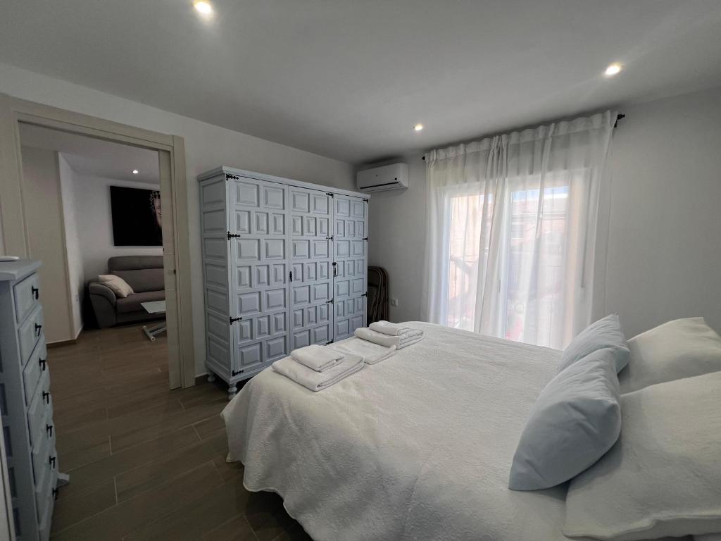 a bedroom with a white bed and a window at Villa Aguas Claras in Escalona