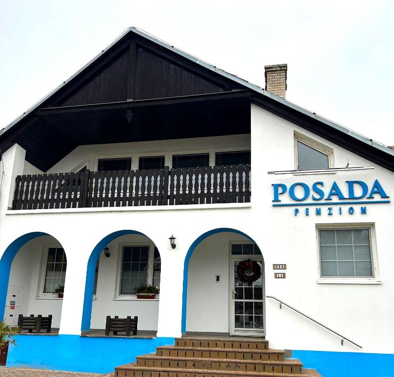 a white building with a sign on it at Penzion POSADA in Podivín