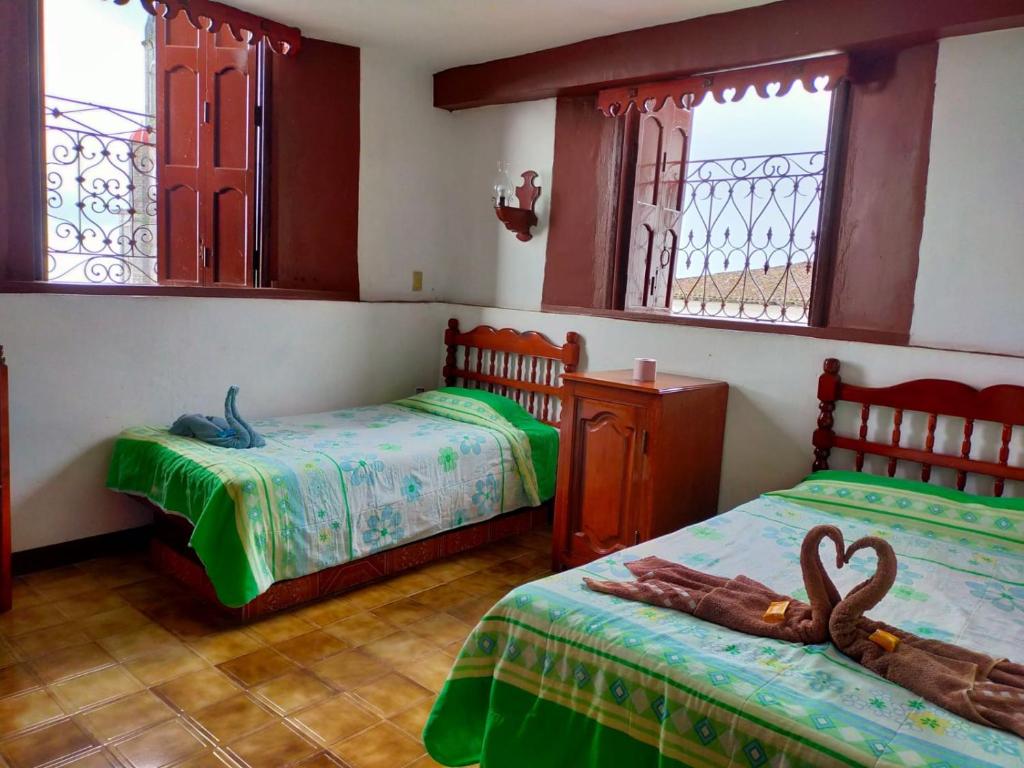 - 2 lits dans une chambre avec 2 fenêtres dans l'établissement HOTEL DANIELA 2, à Cuetzalán del Progreso