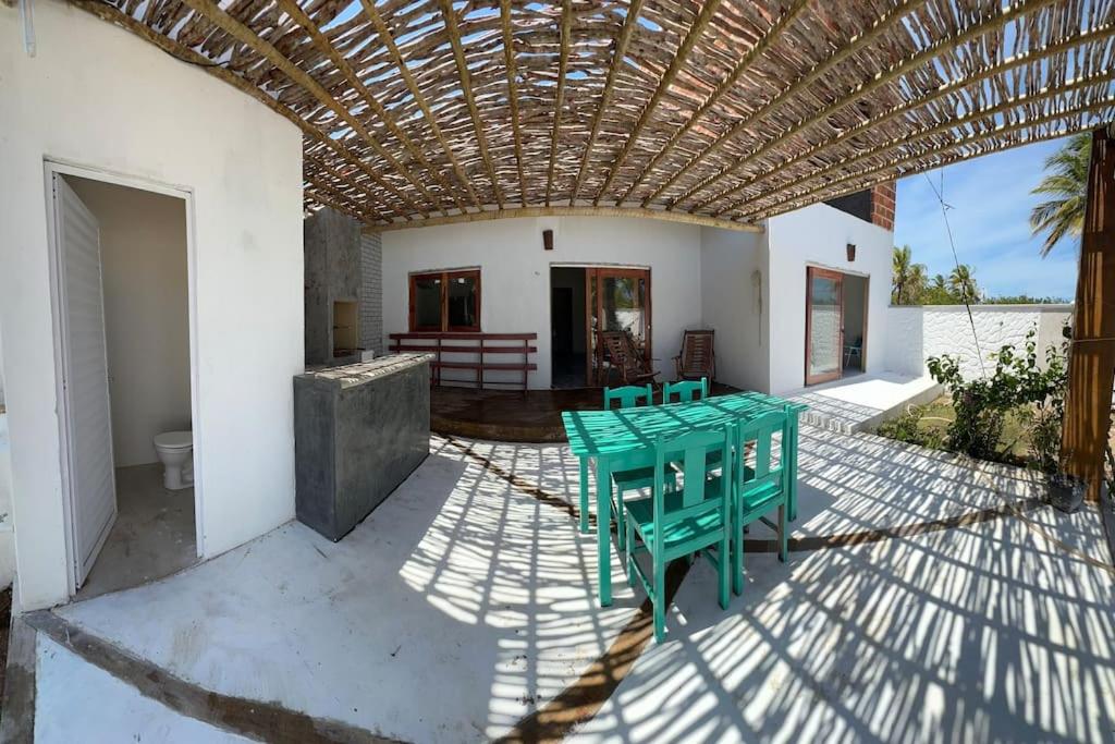 d'une terrasse avec une table et des chaises vertes. dans l'établissement Casa Vento Maré., à Itarema