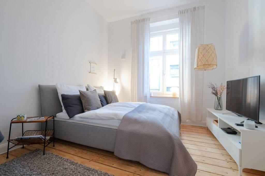 Habitación blanca con cama y TV en Design Altbautraum Wuppertal en Wuppertal