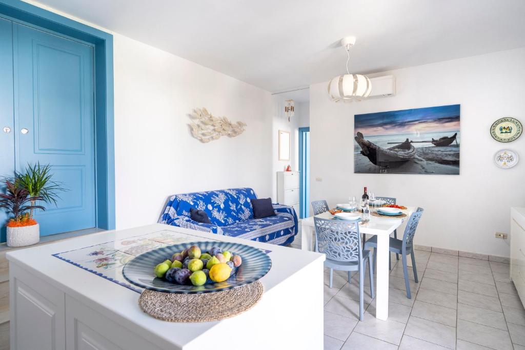 uma cozinha e sala de estar com uma mesa com uma taça de fruta em Casa Luna 100 mt dalla spiaggia em Maruggio