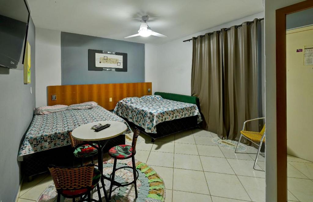 卡爾達斯諾瓦斯的住宿－Condominio Residencial Thermas Place，一间卧室配有两张床和一张桌子及椅子