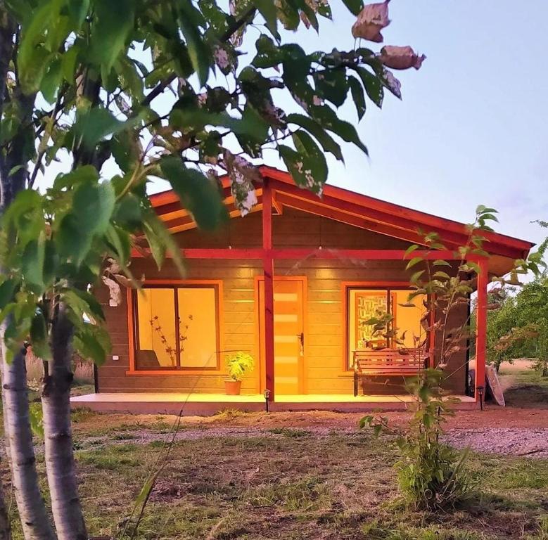 a small wooden house with a red roof at Cabaña Refugio Eluney in Villarrica