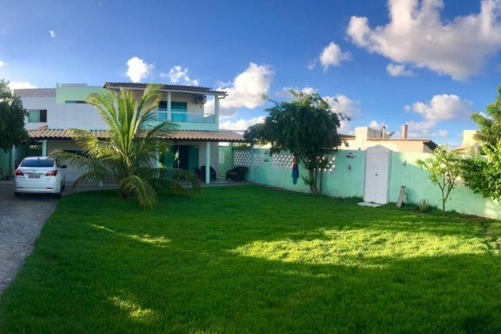 a house with a green lawn in front of it at CASA NA PRAIA DO SACO-SE in Estância