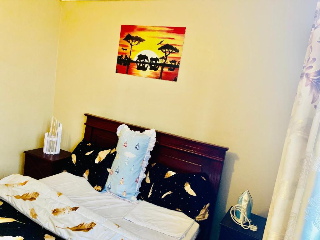 a bedroom with a bed with a picture on the wall at The cape vills in Kampala