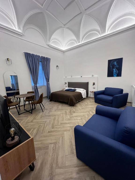 a bedroom with a bed and a couch and a table at Dimora Dei Decumani in Naples