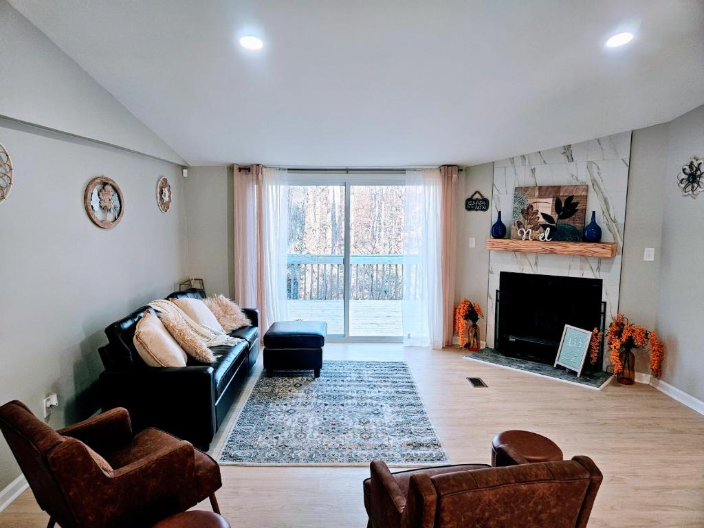 ein Wohnzimmer mit Couch und Kamin in der Unterkunft Da.Luxe Cottage Mtn Island Area on 1.56 Acres in Charlotte