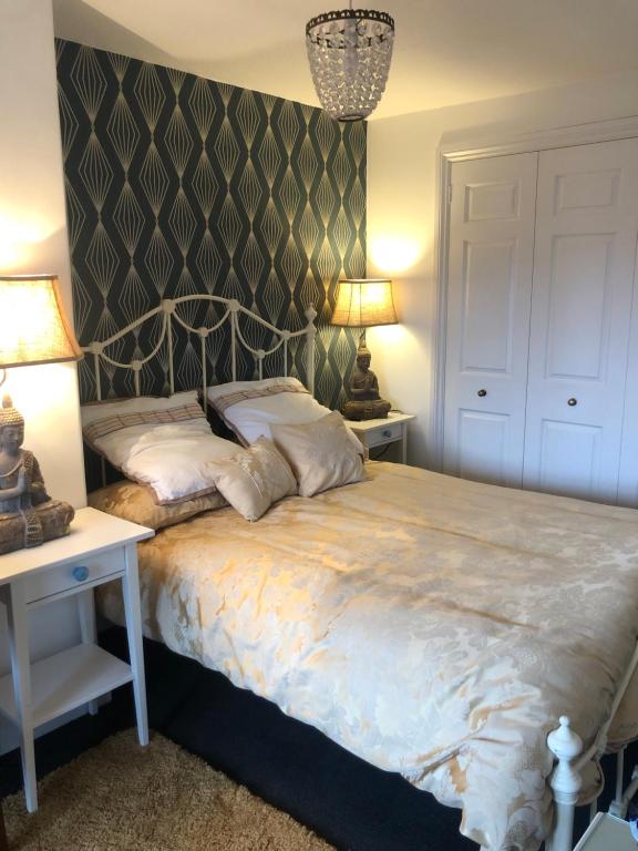 a bedroom with a bed with two tables and two lamps at Lovely room in period townhouse in Winchester