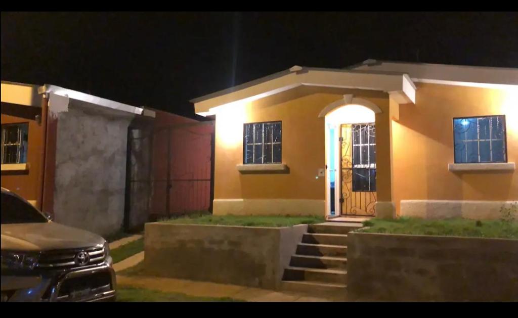 a house with a car parked in front of it at Kami Hostel, Ciudad El Doral in Managua