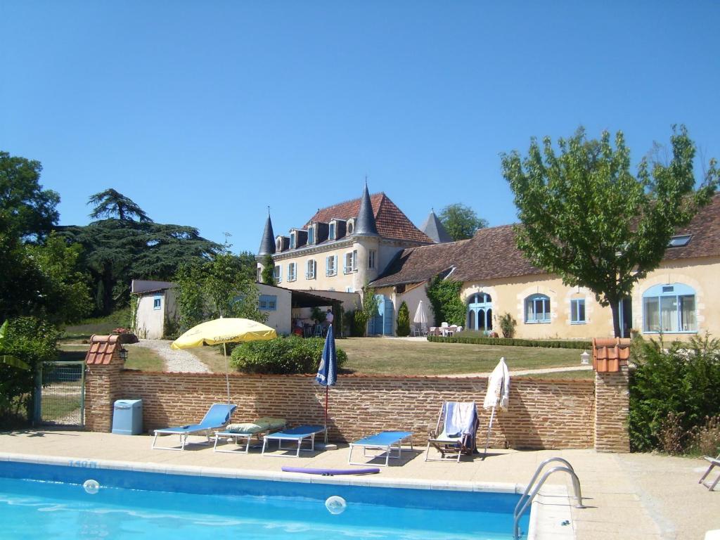 a house with a swimming pool in front of a house at Corail in Queyssac