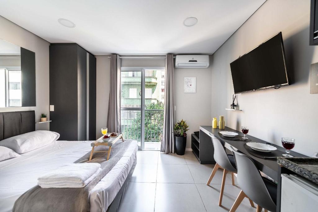 a bedroom with a bed and a table and a desk at BA60 Studio Aconchegante Bela Vista São Paulo TPA in São Paulo