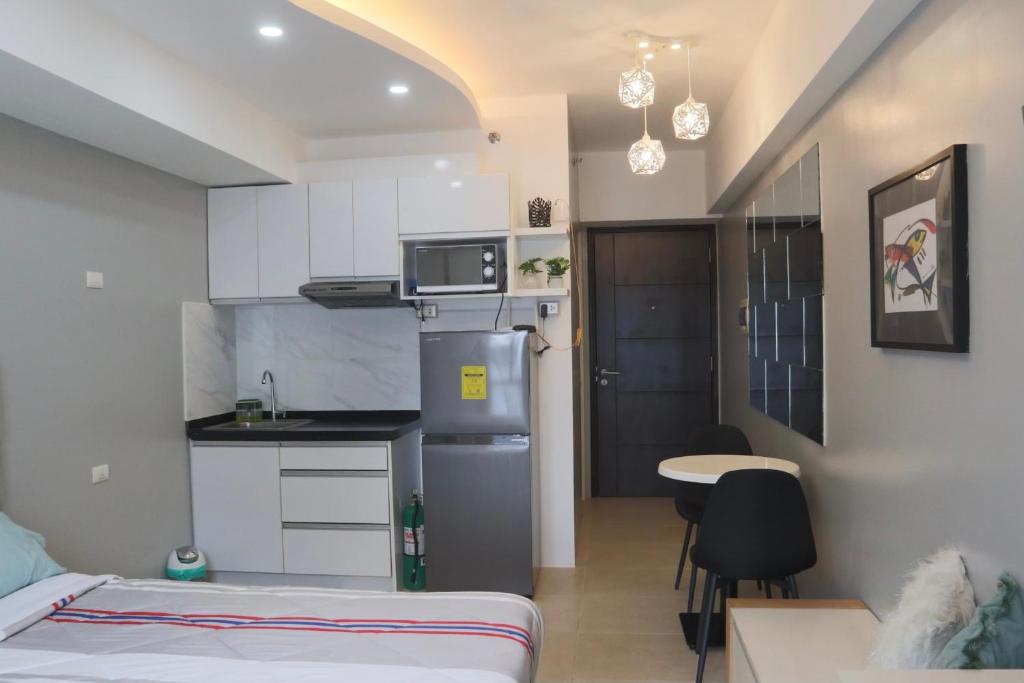 een kleine kamer met een bed en een keuken bij City Haven at Avida Riala Towers in Cebu City
