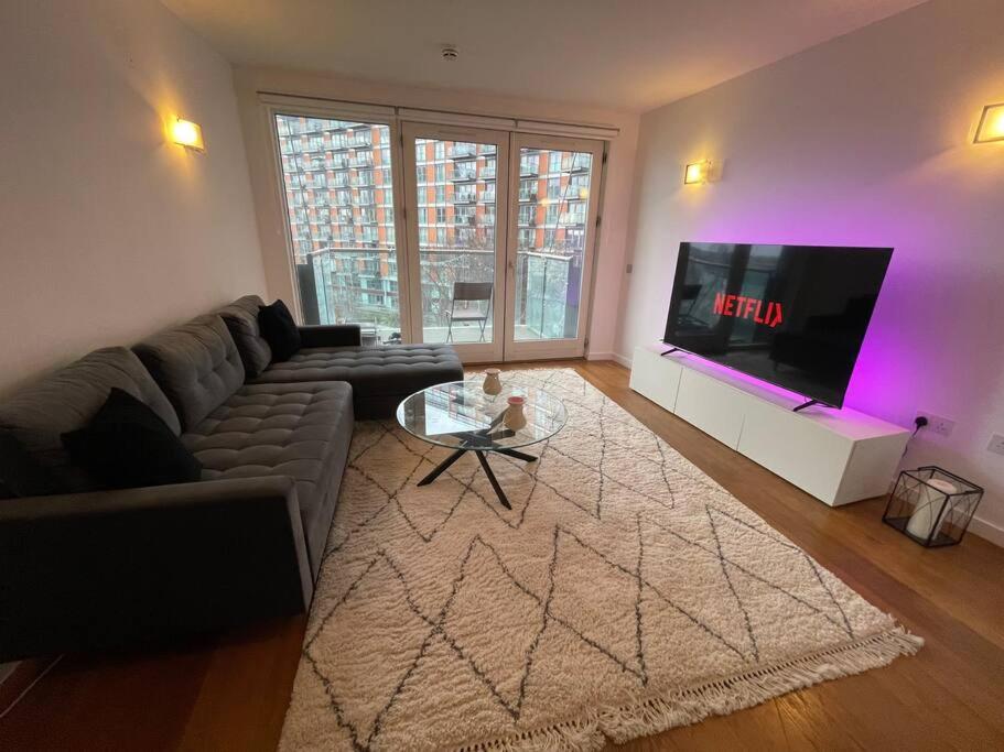 a living room with a couch and a tv at 1 Bed Modern Flat in London