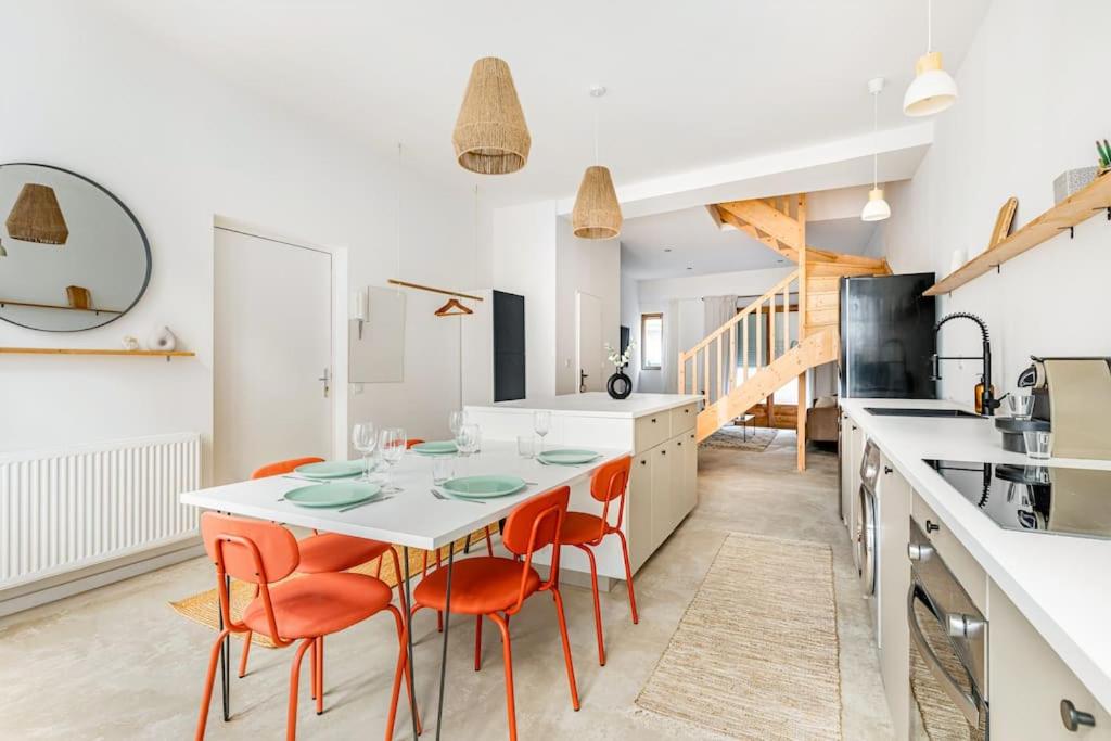 - une cuisine avec une table blanche et des chaises orange dans l'établissement Adelaïde, à Saint-Étienne