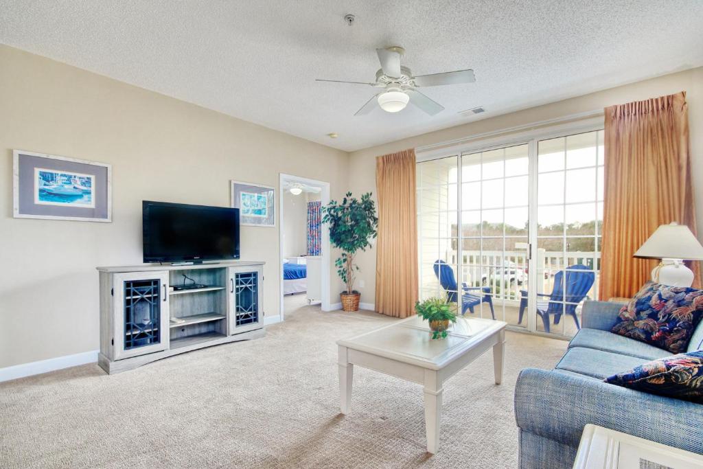 a living room with a couch and a tv at Palmy Days @ Ironwood 424 in Myrtle Beach