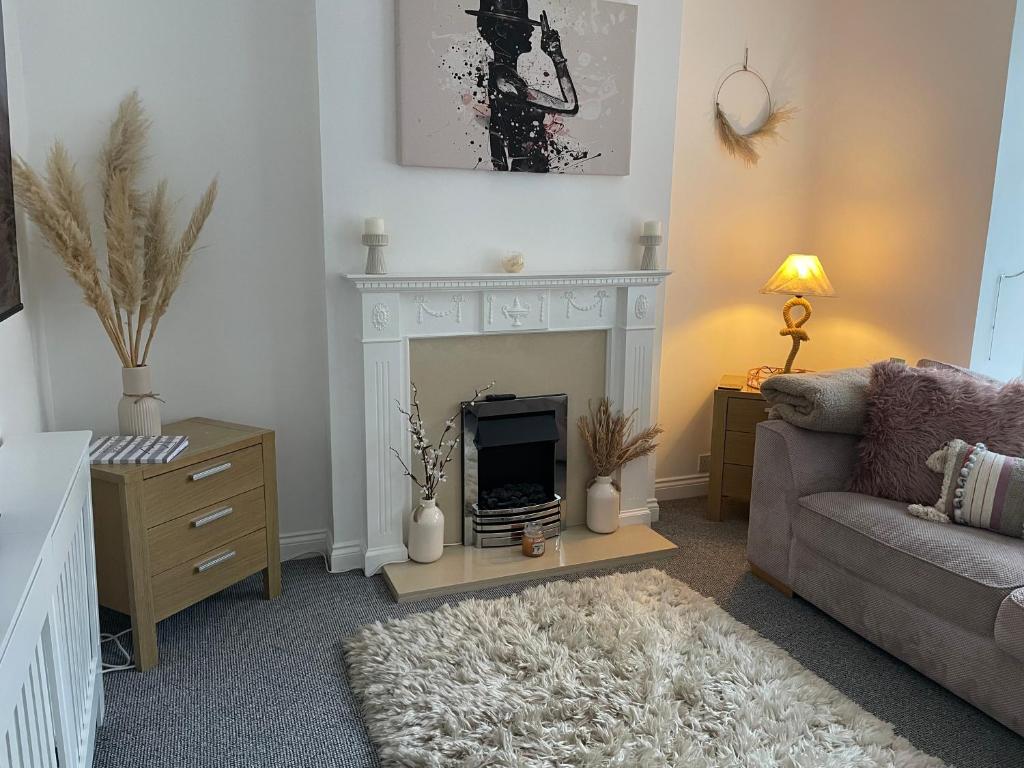 a living room with a fireplace and a couch at Central Blue Holiday Home. in Bridlington