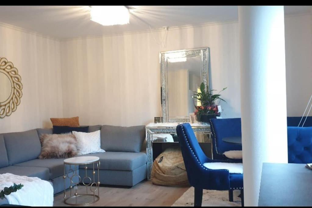 un soggiorno con divano blu e specchio di Niklas Ålesund City Center Apt. (sleep: 3 pers). ad Ålesund